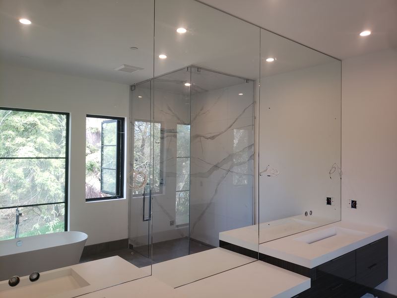 Custom-cut frameless mirror with precision lighting and outlet cutouts, Charlotte NC