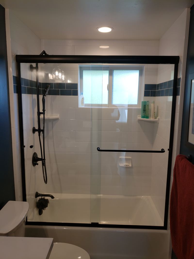 Semi-frameless sliding tub door, matte black Euro-style header, Mount Holly NC